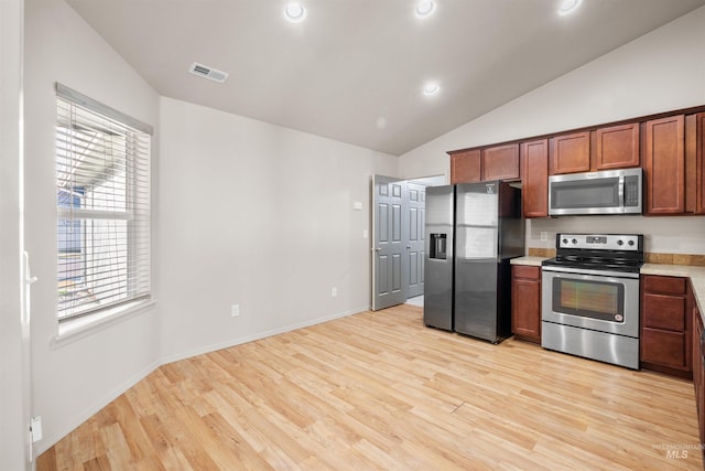 kitchen featuring stainless steel appliances, light wood-style flooring, visible vents, lofted ceiling, and light countertops