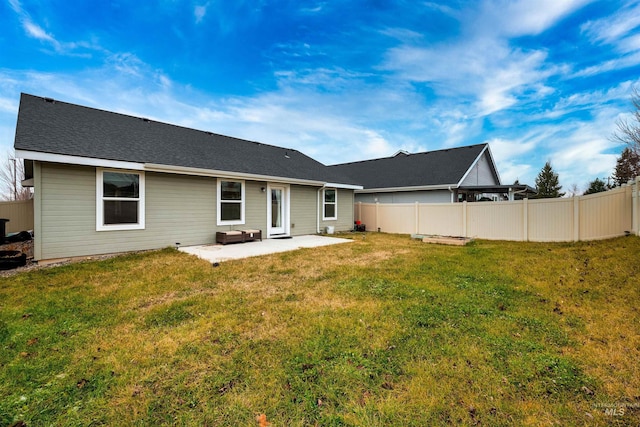 back of house with fence, a patio area, and a lawn