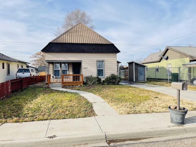 bungalow-style home with a front yard and a shed