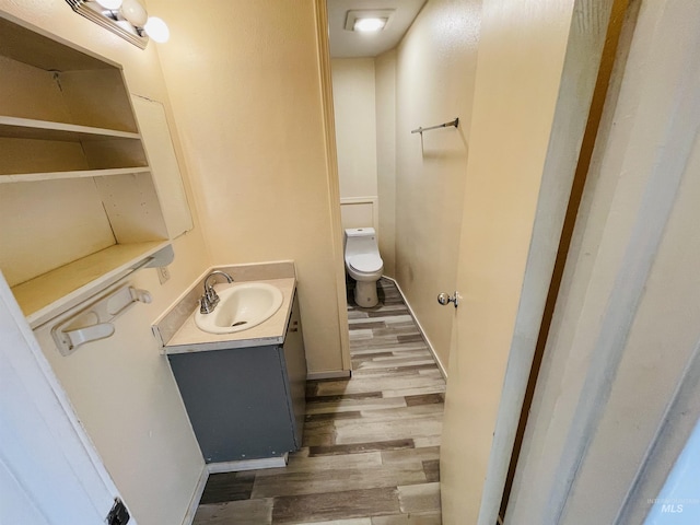 bathroom with vanity, hardwood / wood-style flooring, and toilet