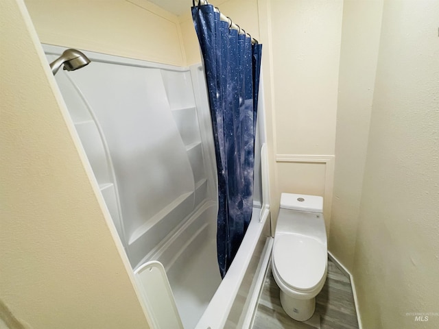 bathroom with a shower with curtain and toilet