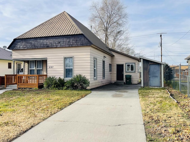 view of front of home with an outbuilding, a front lawn, and covered porch