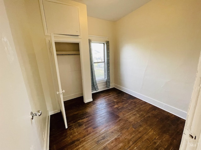 unfurnished bedroom with dark wood-type flooring