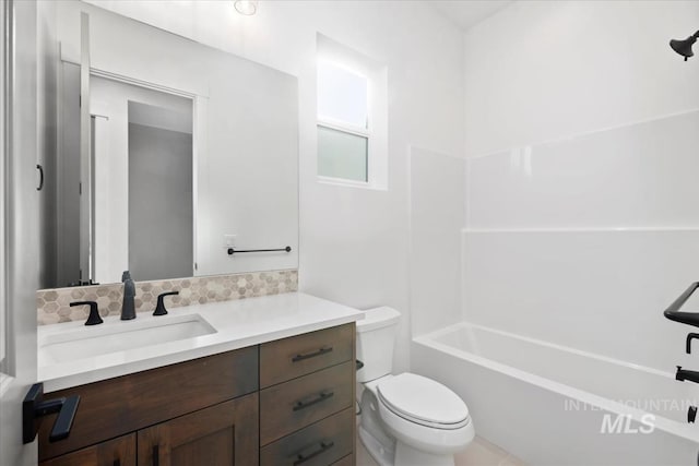 full bath featuring vanity, toilet, and backsplash