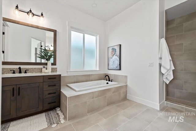 full bathroom with tile patterned floors, tiled shower, vanity, and a garden tub