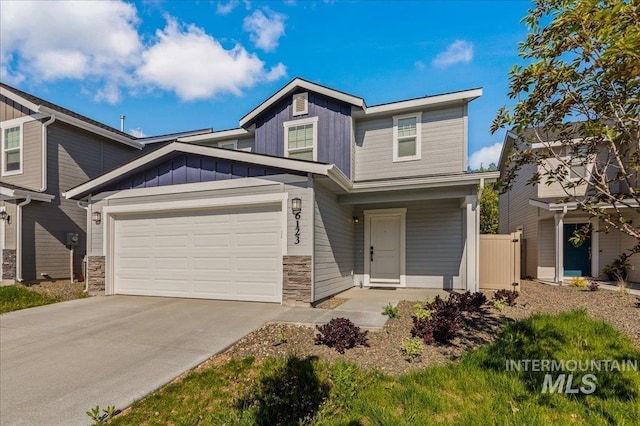 craftsman-style house featuring driveway, stone siding, an attached garage, and board and batten siding