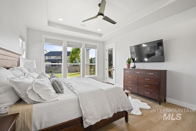 5445 S Mesa Trail Pl, Meridian, ID 83642 - bedroom with baseboards, light wood-type flooring, a tray ceiling, ceiling fan, and access to outside
