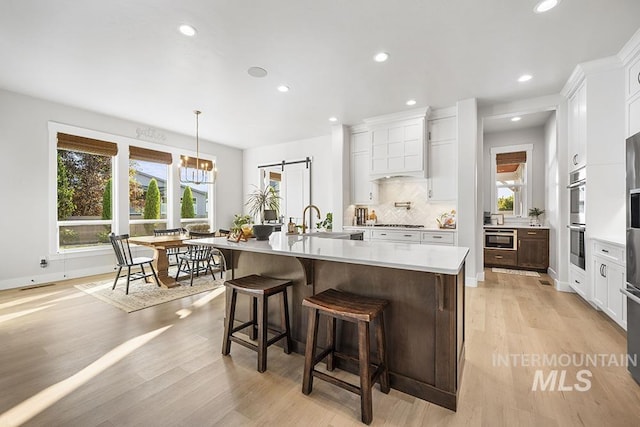 5445 S Mesa Trail Pl, Meridian, ID 83642 - kitchen featuring a sink, light countertops, plenty of natural light, backsplash, and recessed lighting