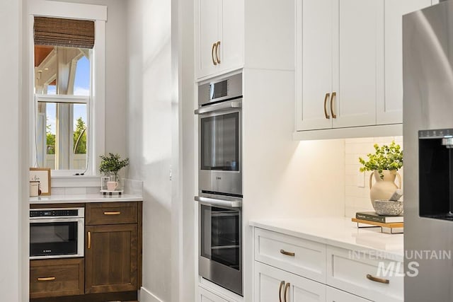 5445 S Mesa Trail Pl, Meridian, ID 83642 - kitchen featuring stainless steel appliances, tasteful backsplash, light countertops, white cabinetry, and baseboards