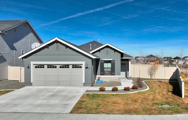 view of front of house featuring board and batten siding, concrete driveway, fence, and a garage