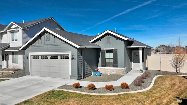 view of front of home featuring concrete driveway, a shingled roof, board and batten siding, and fence