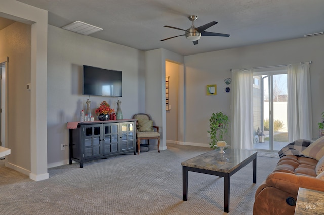 carpeted living room with baseboards, visible vents, and a ceiling fan