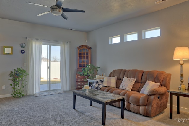 living room featuring light colored carpet, visible vents, ceiling fan, and baseboards