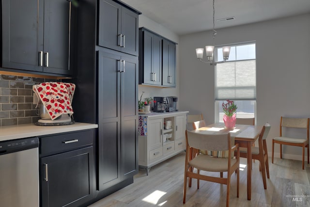 kitchen featuring light wood-style flooring, visible vents, light countertops, stainless steel dishwasher, and tasteful backsplash