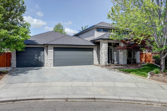 570 E Ocelot, Meridian, ID 83646 - prairie-style house featuring stone siding, an attached garage, fence, concrete driveway, and a shingled roof