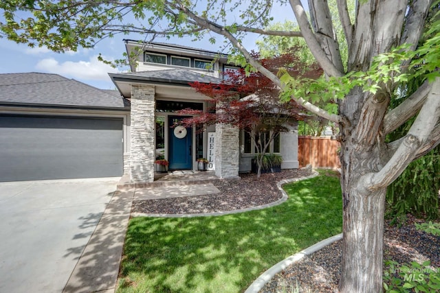 570 E Ocelot, Meridian, ID 83646 - view of front of house featuring an attached garage, fence, concrete driveway, stone siding, and a shingled roof