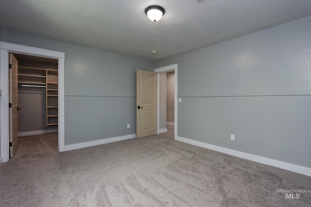 570 E Ocelot, Meridian, ID 83646 - unfurnished bedroom featuring carpet floors, baseboards, a walk in closet, a closet, and a textured ceiling