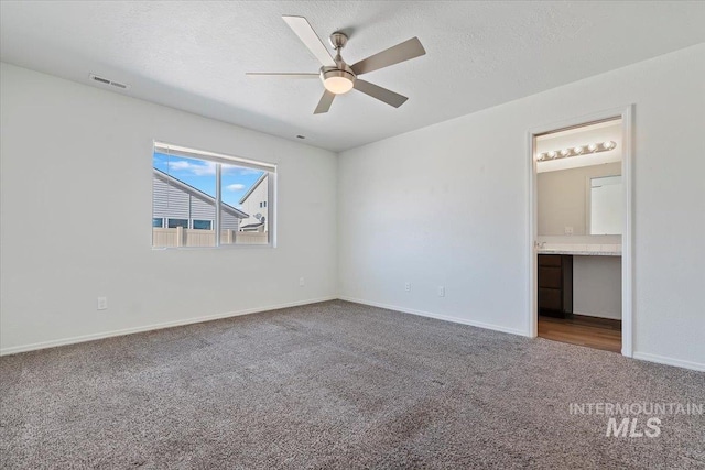 spare room featuring carpet, a textured ceiling, and ceiling fan