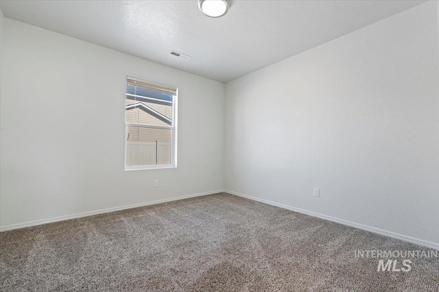 carpeted empty room featuring a textured ceiling