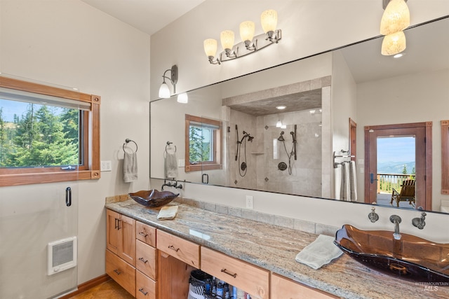 bathroom with a tile shower, plenty of natural light, and vanity