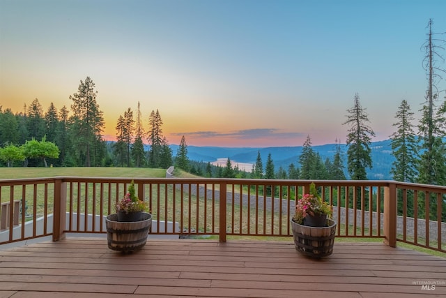 deck at dusk featuring a mountain view