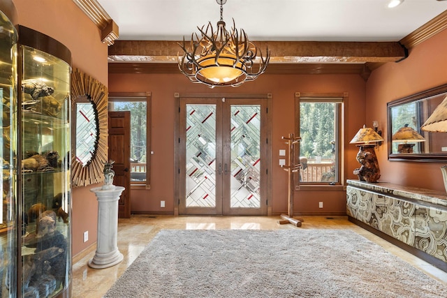 foyer entrance with french doors, ornamental molding, a chandelier, and baseboards