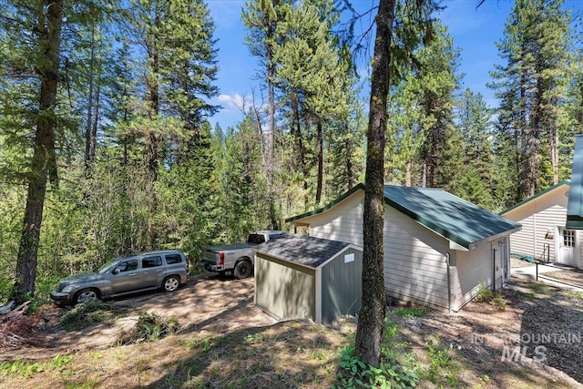 104 Sky Ridge Dr, Garden Valley, ID 83622 - view of side of property featuring a shed, an outdoor structure, and a view of trees