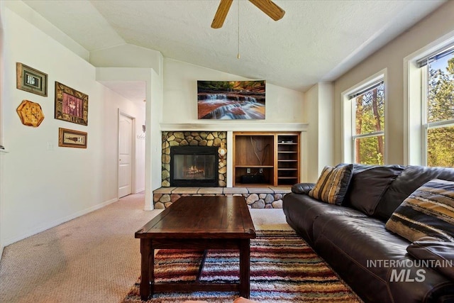 104 Sky Ridge Dr, Garden Valley, ID 83622 - carpeted living area featuring healthy amount of natural light, ceiling fan, vaulted ceiling, baseboards, and a fireplace