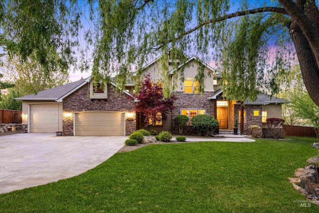view of front facade with fence, an attached garage, stone siding, concrete driveway, and a lawn