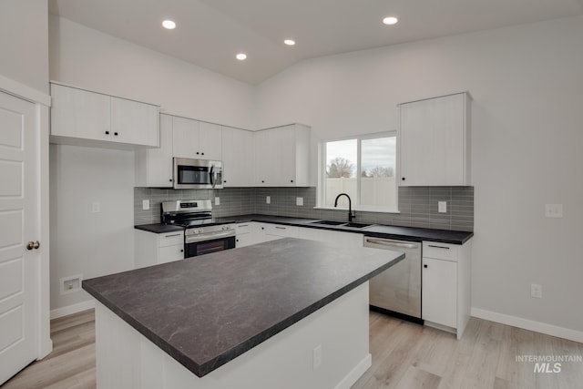 kitchen featuring white cabinetry, stainless steel appliances, sink, and a kitchen island