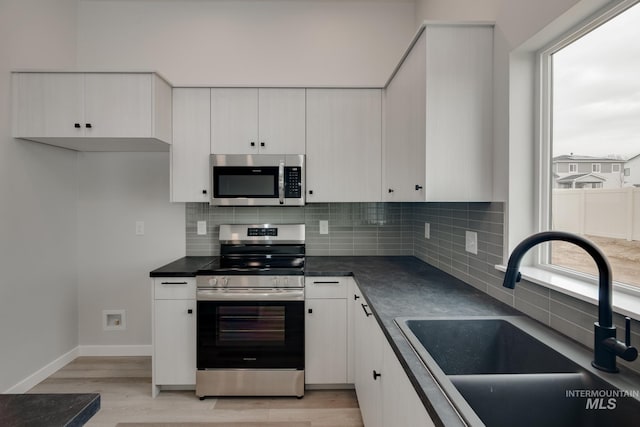 7417 E Shields Dr, Nampa, ID 83687 - kitchen featuring a sink, stainless steel appliances, light wood-style floors, and dark countertops