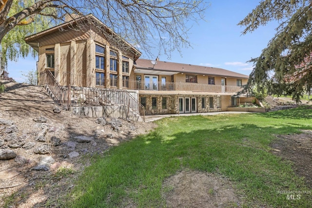 569 Spring Creek Rd, Burley, ID 83318 - back of property with stairway, a yard, french doors, and brick siding