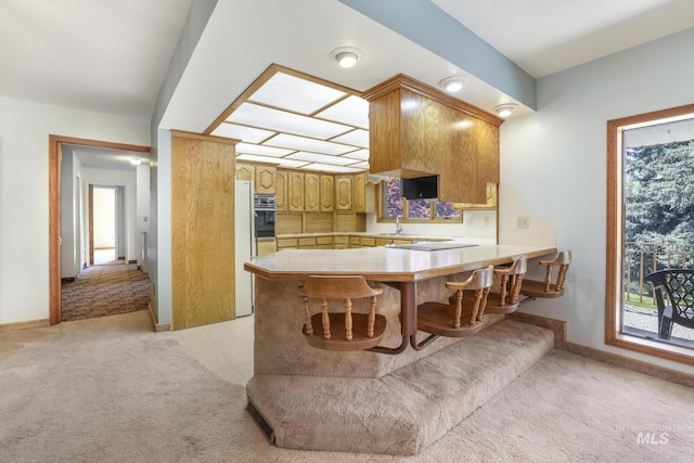 569 Spring Creek Rd, Burley, ID 83318 - kitchen with wall oven, a peninsula, light countertops, and light carpet