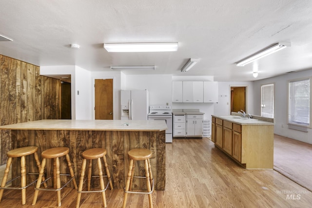 569 Spring Creek Rd, Burley, ID 83318 - kitchen with white appliances, light wood-style floors, a kitchen breakfast bar, light countertops, and a peninsula