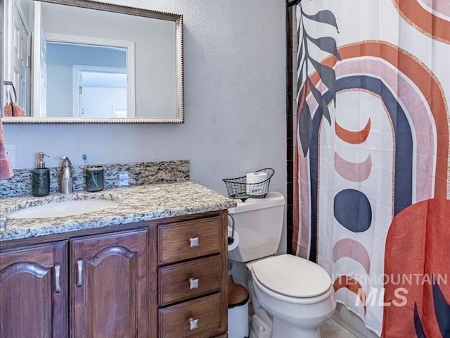 bathroom with vanity, a shower with curtain, and toilet