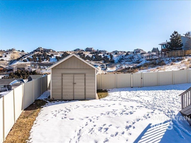 yard layered in snow with a storage shed