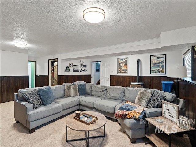 carpeted living room with wooden walls and a textured ceiling