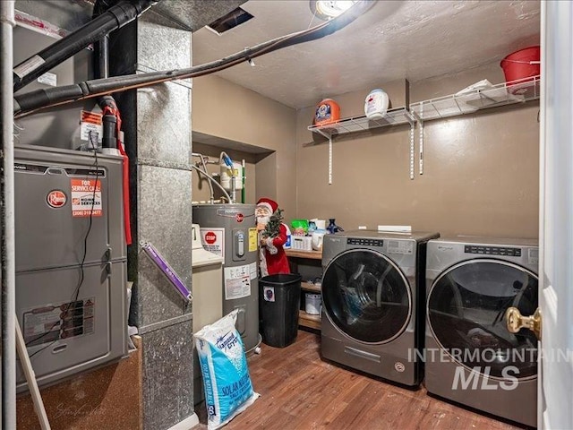 laundry room featuring hardwood / wood-style flooring, separate washer and dryer, and electric water heater