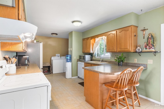 230 Sage St, Kimberly, ID 83341 - kitchen featuring white appliances, independent washer and dryer, a kitchen bar, under cabinet range hood, and a peninsula