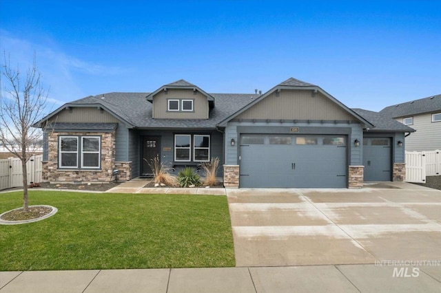 craftsman-style home with a garage, stone siding, a front yard, and fence