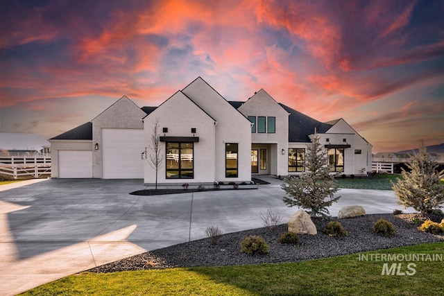 view of front of home featuring concrete driveway, fence, and an attached garage