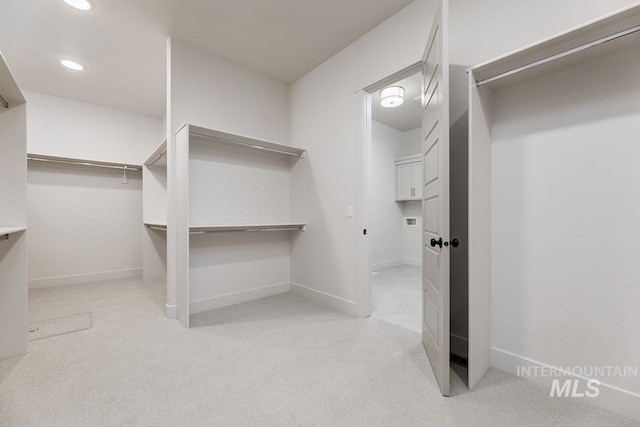 walk in closet featuring light carpet