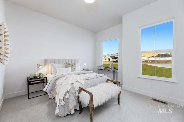 bedroom with carpet floors, visible vents, and baseboards