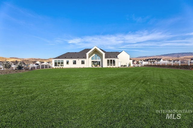 back of house featuring a yard and fence