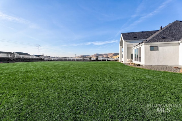 view of yard featuring fence and a mountain view