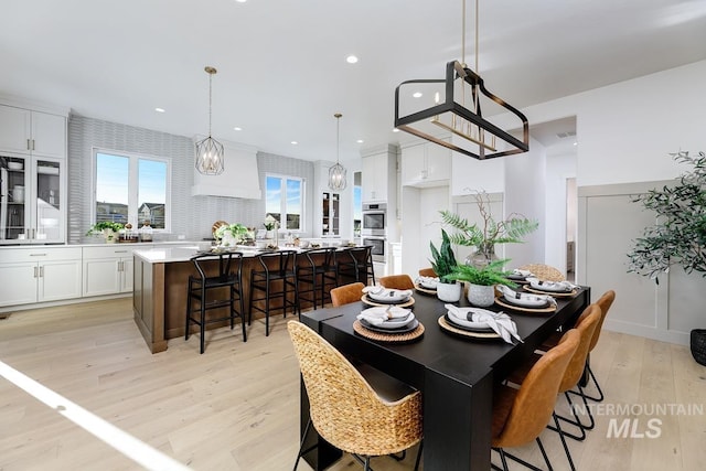 dining space with a notable chandelier, light wood finished floors, visible vents, and recessed lighting