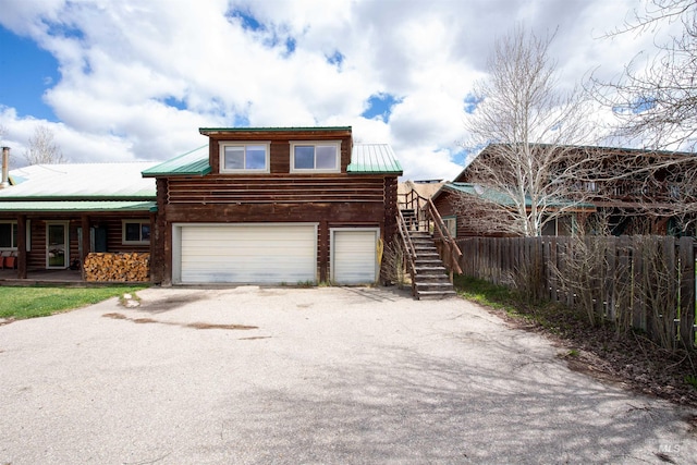 130 Valley Creek Rd, Stanley, ID 83278 - view of front facade with stairs, asphalt driveway, a garage, and metal roof