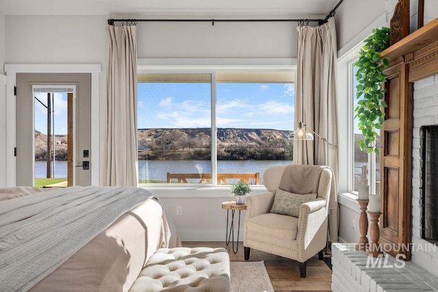 bedroom featuring a water view and wood finished floors