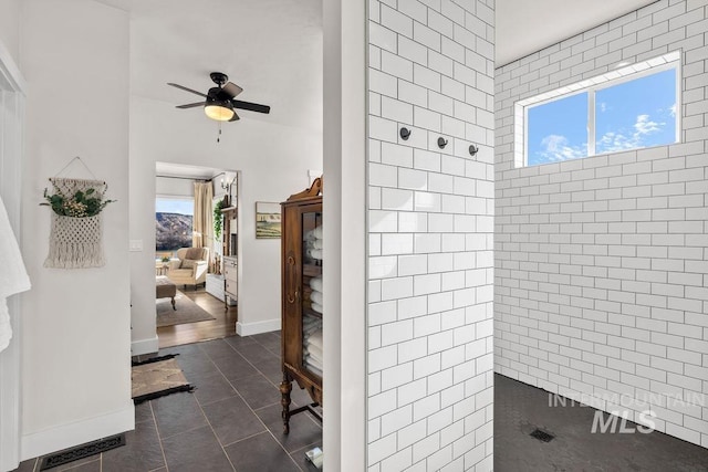 ensuite bathroom with baseboards, ceiling fan, ensuite bathroom, and tile patterned floors