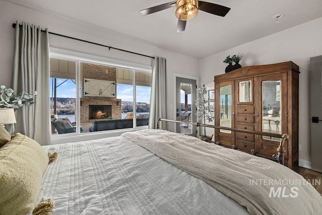 bedroom featuring a brick fireplace and a ceiling fan